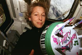 Candid view of STS-81 mission specialist Marsha Ivins on the Atlantis's aft flight deck with an inflated birthday cake which was sent for mission specialist Jerry Linenger.